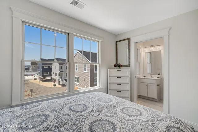 a bathroom with a toilet a sink a mirror a vanity and shower