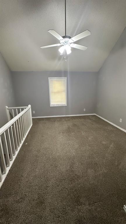 1221 Abrams Road, Unit 109 Dallas, TX 75214 - Photo 9 of 10 Vaulted ceiling with a ceiling fan light fixture, gray painted walls, and dark brown carpeting