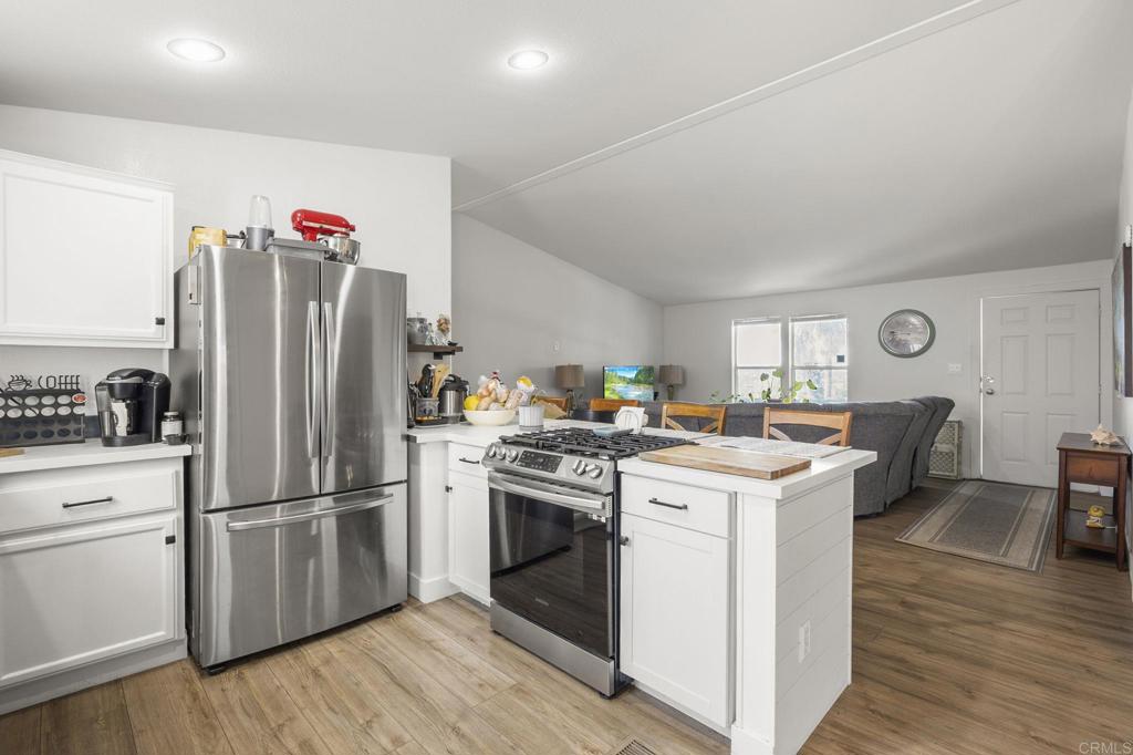 224 Astro Court Vista, CA 92083 - Photo 22 of 47 a kitchen with a refrigerator a stove top oven and a dining table