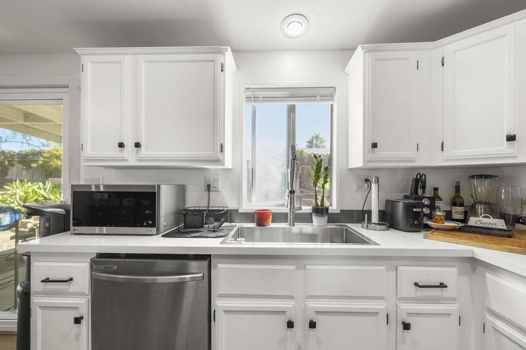 224 Astro Court Vista, CA 92083 - Photo 23 of 47 a kitchen with stainless steel appliances white cabinets and a sink