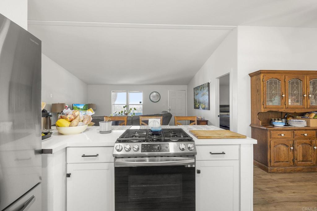 224 Astro Court Vista, CA 92083 - Photo 24 of 47 a kitchen that has a stove and a white wooden cabinets