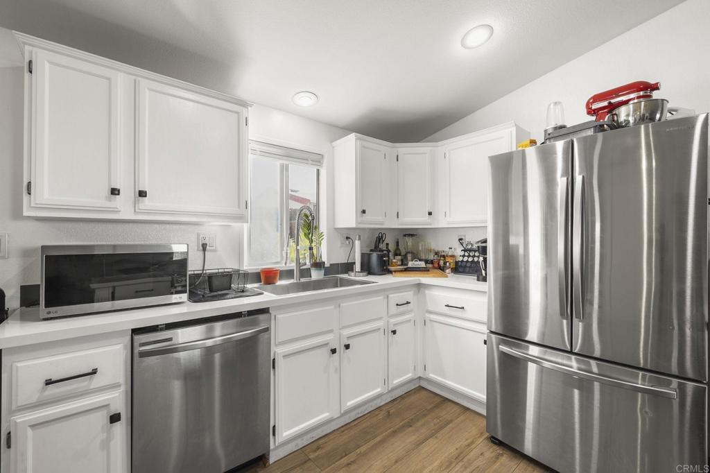 224 Astro Court Vista, CA 92083 - Photo 25 of 47 a kitchen with white cabinets and stainless steel appliances
