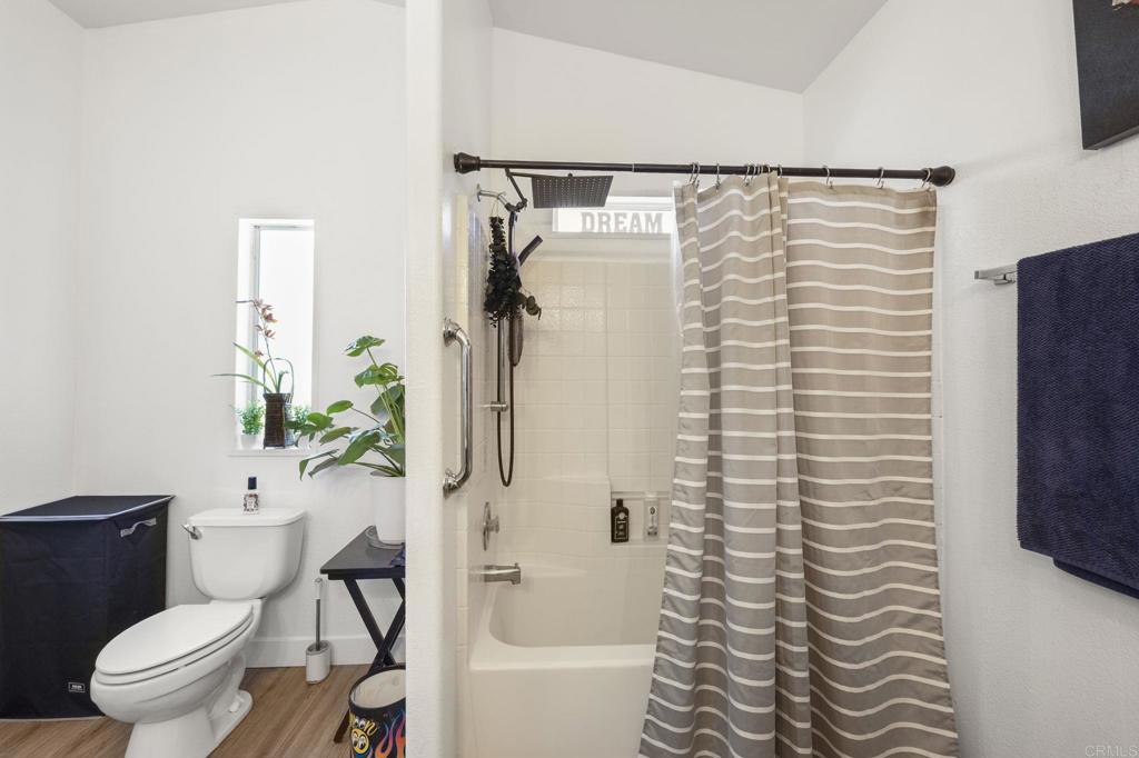 224 Astro Court Vista, CA 92083 - Photo 29 of 47 a bathroom with a toilet and a shower curtain