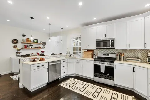 a kitchen with a sink stove and white cabinets