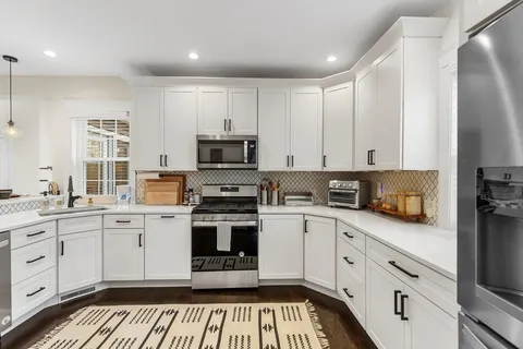 a kitchen with stainless steel appliances granite countertop a stove a sink and a refrigerator