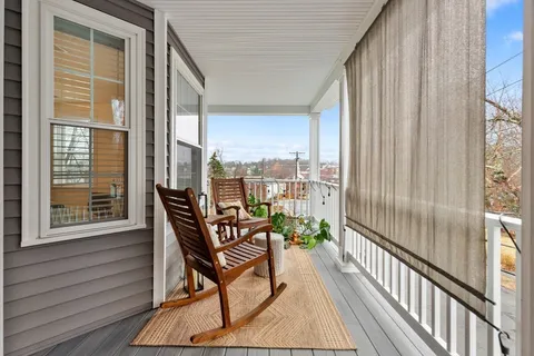 a view of a balcony with furniture and wooden floor