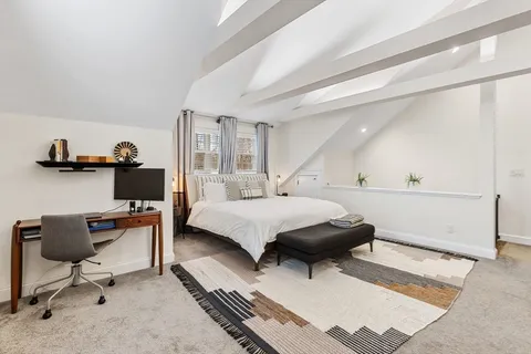 a bedroom with a bed and a chair in it