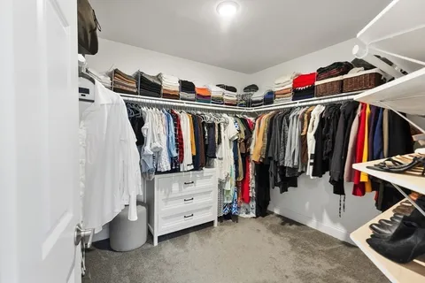 a view of walk in closet with clothes and shoes