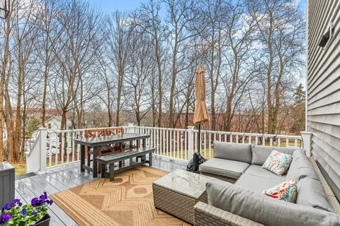 a roof deck with couches and wooden floor