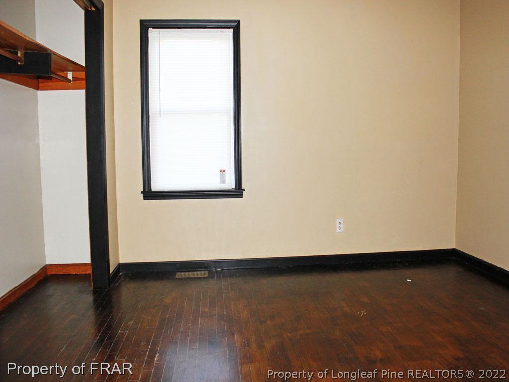 7621 Decatur Drive Fayetteville, NC 28303 - Photo 11 of 15 an empty room with wooden floor and windows