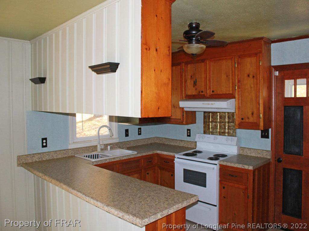 7621 Decatur Drive Fayetteville, NC 28303 - Photo 4 of 15 a kitchen with stainless steel appliances granite countertop a sink a stove and a refrigerator
