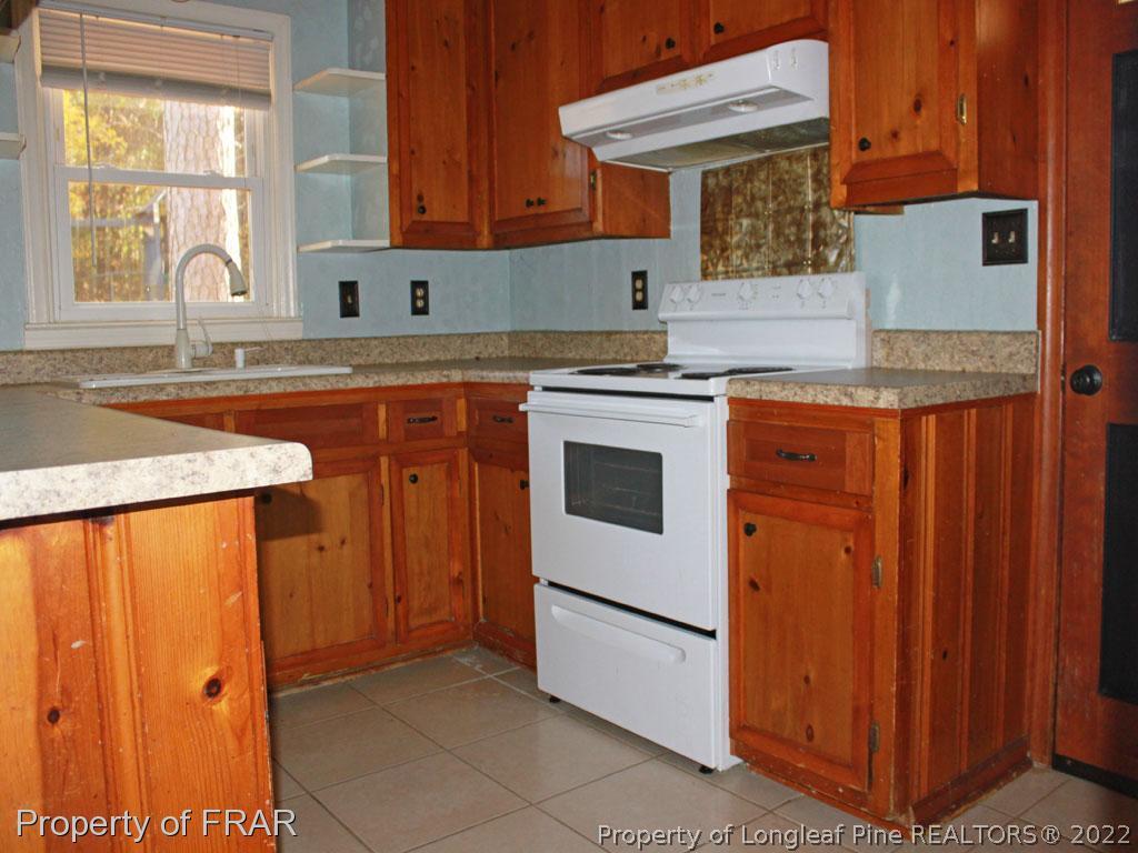 7621 Decatur Drive Fayetteville, NC 28303 - Photo 5 of 15 a kitchen with stainless steel appliances granite countertop a sink stove and refrigerator