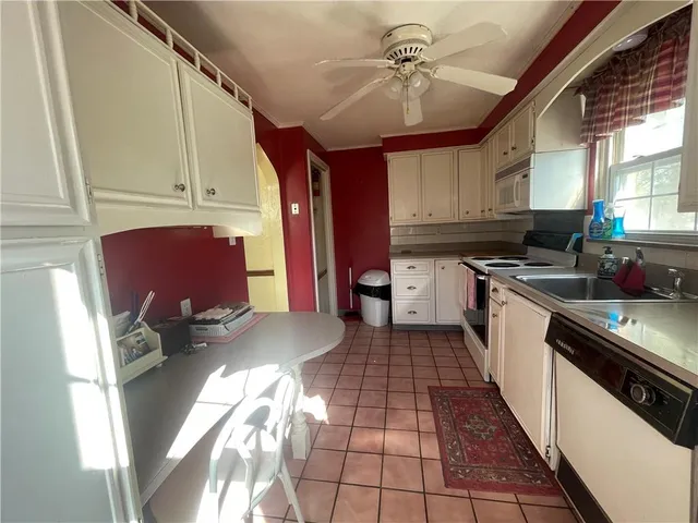 a kitchen with stainless steel appliances granite countertop a stove a sink dishwasher and cabinets with wooden floor