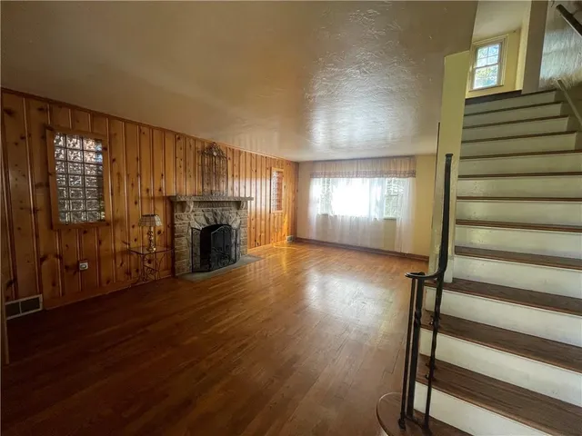 a view of a livingroom with wooden floor fireplace and windows