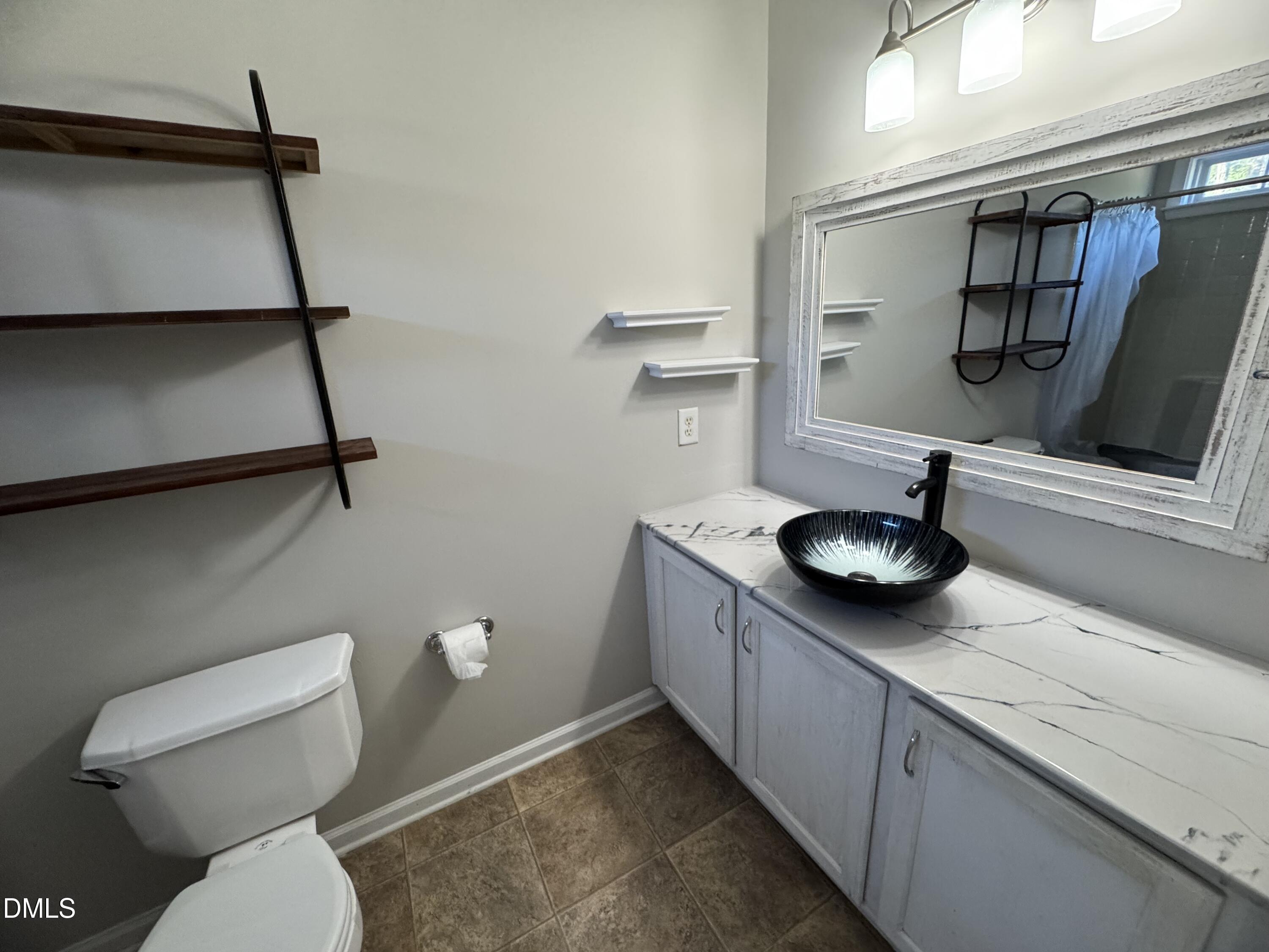 4008 Landover Lane Raleigh, NC 27616 - Photo 11 of 19 a bathroom with a toilet sink and mirror