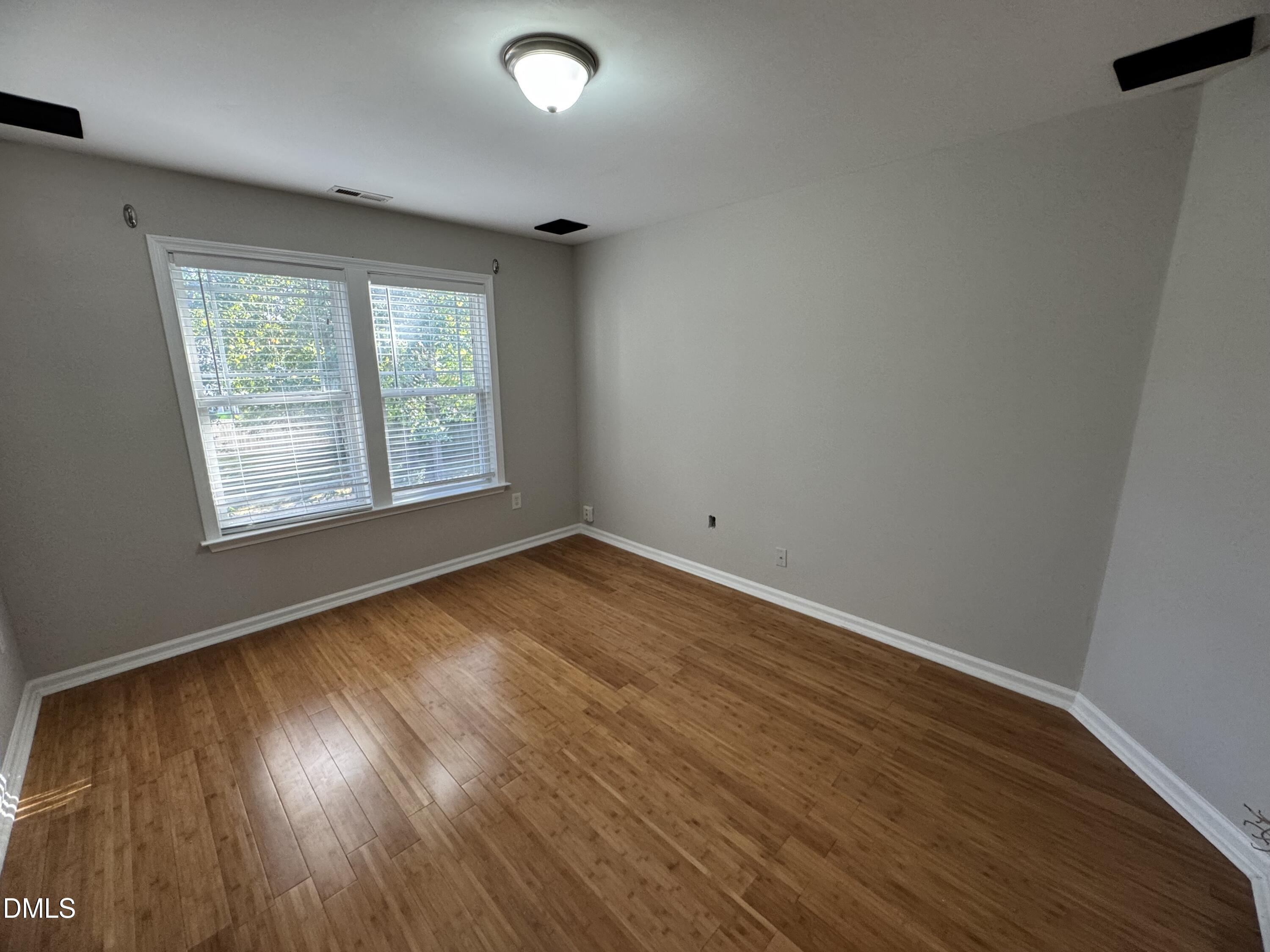 4008 Landover Lane Raleigh, NC 27616 - Photo 14 of 19 an empty room with wooden floor and windows