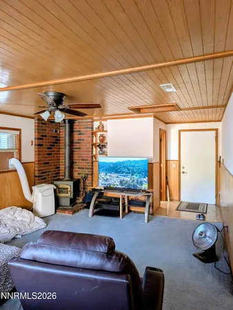 a living room with furniture a flat screen tv and large window
