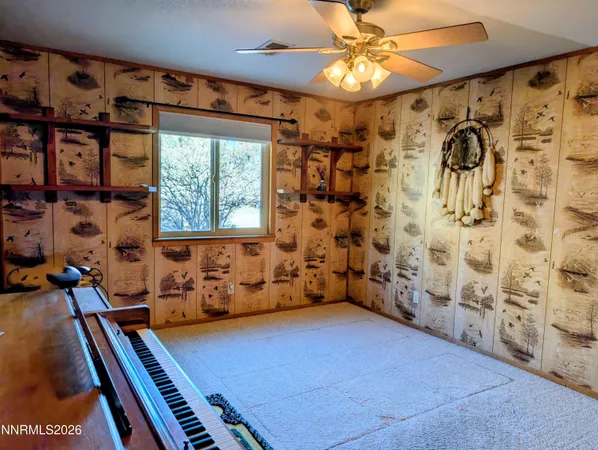 a backyard of a house with wooden table and chairs