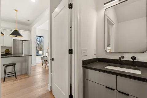 a bathroom with a granite countertop sink toilet mirror and bathtub