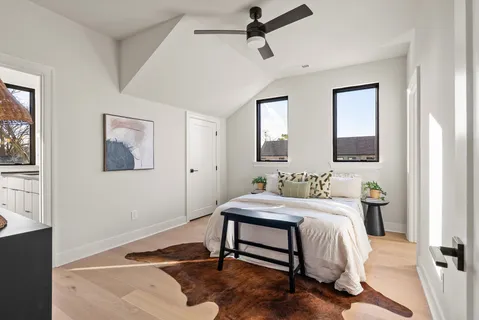 a living room with furniture and a potted plant next to a window