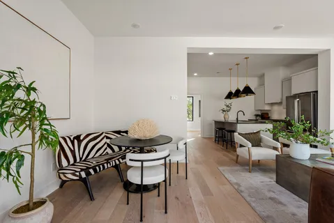 a living room with furniture a large window and a chandelier