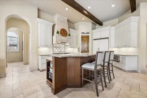 a kitchen with stainless steel appliances kitchen island granite countertop a table and chairs in it