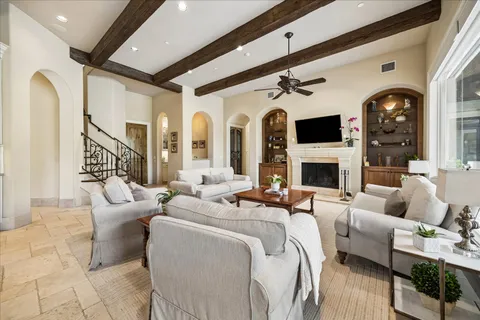 a living room with furniture a fireplace and a floor to ceiling window