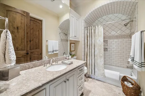 a bathroom with a granite countertop sink two mirror and a shower