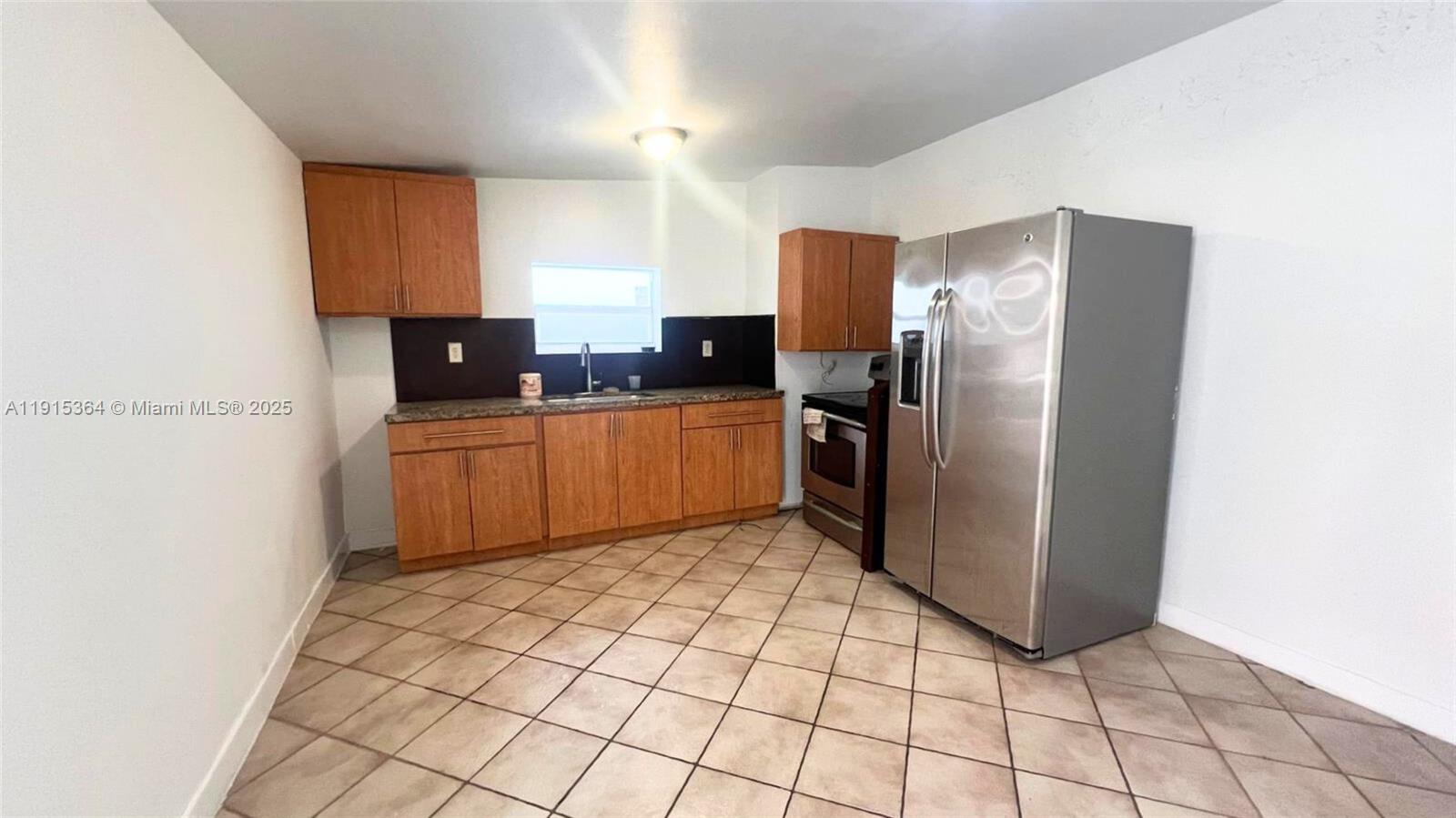 6481 Southwest 39th Terrace, Unit 2 Miami, FL 33155 - Photo 3 of 7 a kitchen with stainless steel appliances a refrigerator sink and cabinets