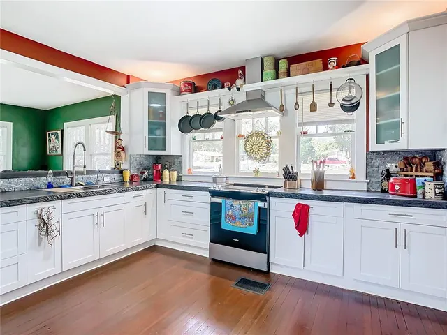 a open kitchen with granite countertop a white stove and sink