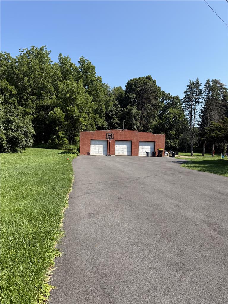 4023 Oakland Road Bethlehem, PA 18020 - Photo 8 of 14 A long paved driveway leads to a versatile brick outbuilding, offering ample parking and storage.