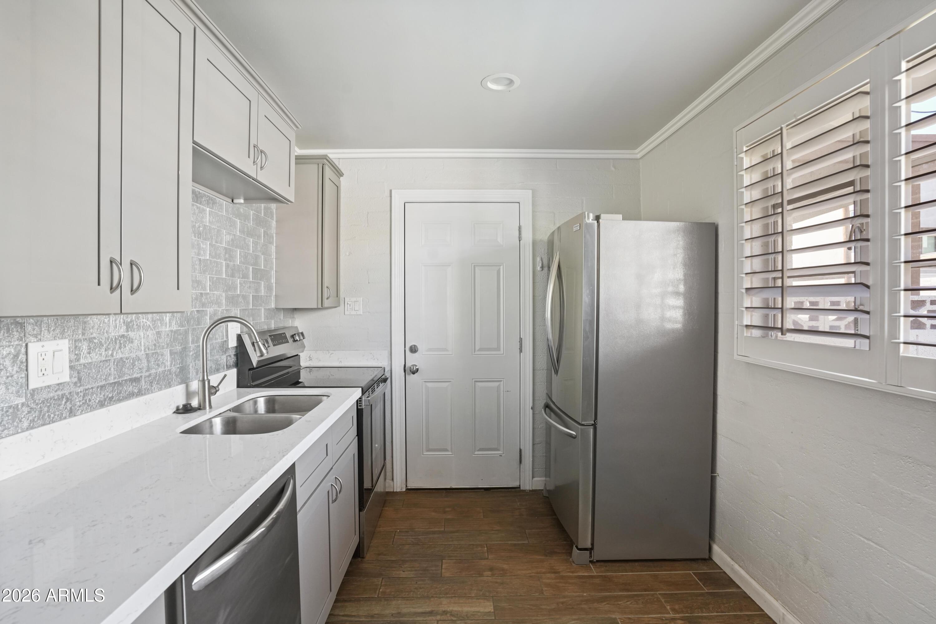 3426 North Miller Road, Unit 8 Scottsdale, AZ 85251 - Photo 8 of 10 a kitchen with stainless steel appliances granite countertop a refrigerator and a sink