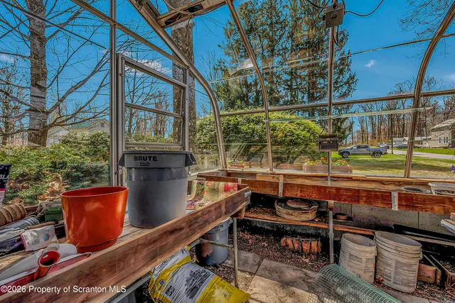 a view of a big room with large trees and a wooden fence