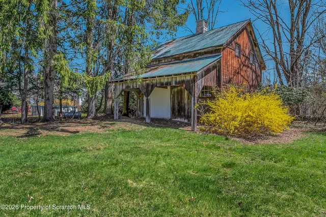 a view of a yard with plants and brick wall
