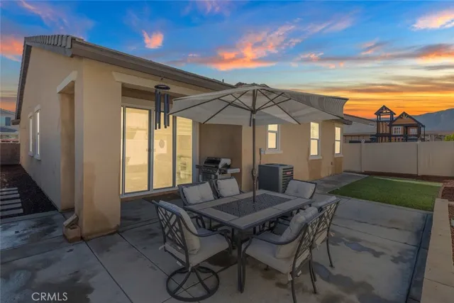a view of a patio with table and chairs with wooden floor and fence
