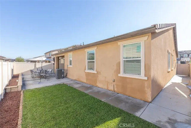 a backyard of a house with table and chairs