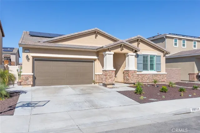 a front view of a house with a yard and potted plants