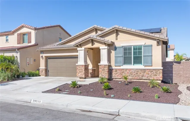a front view of a house with a yard and potted plants