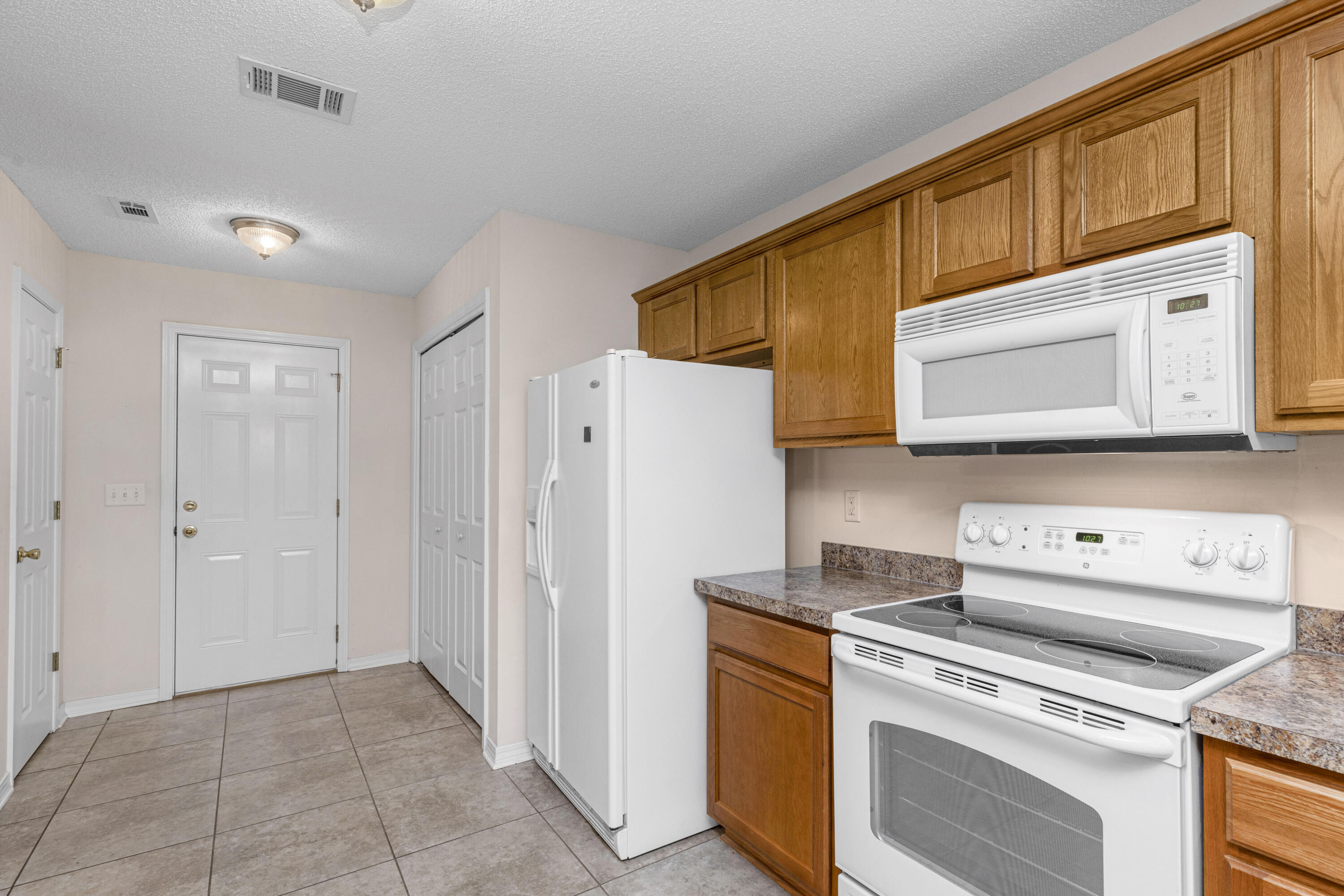 2864 Soles Lane Crestview, FL 32539 - Photo 16 of 32 a kitchen with a stove a refrigerator and a microwave