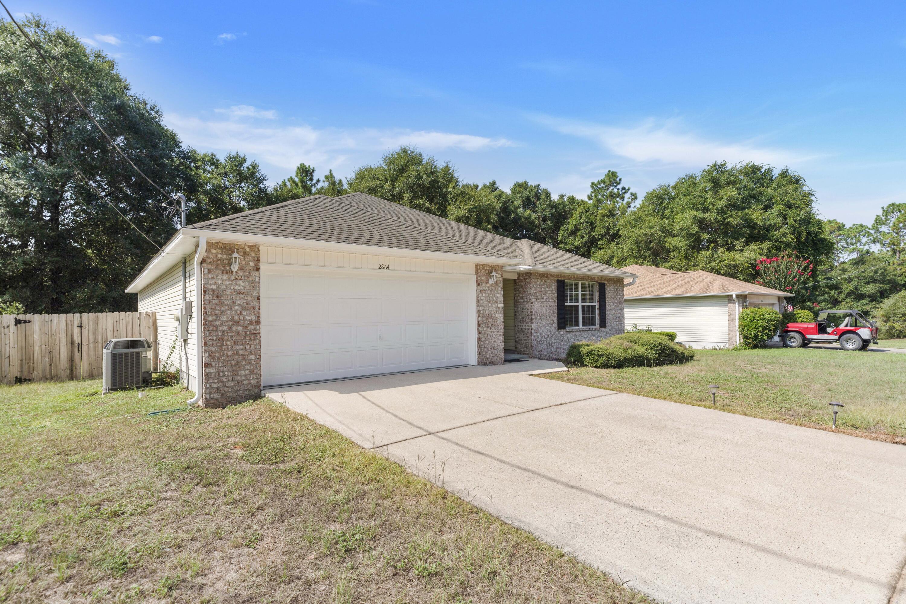 2864 Soles Lane Crestview, FL 32539 - Photo 2 of 32 a front view of a house with a yard and garage
