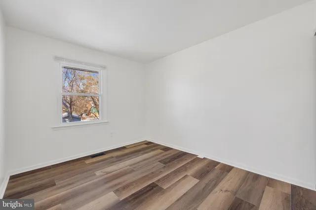 a view of empty room with window and ceiling fan