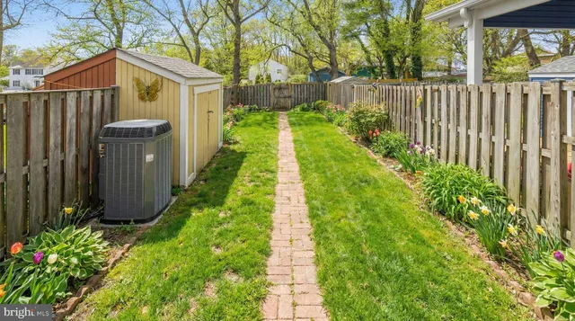 a view of a house with wooden fence next to a yard