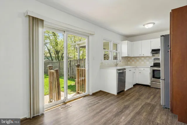 a view of a hallway with wooden floor and a window