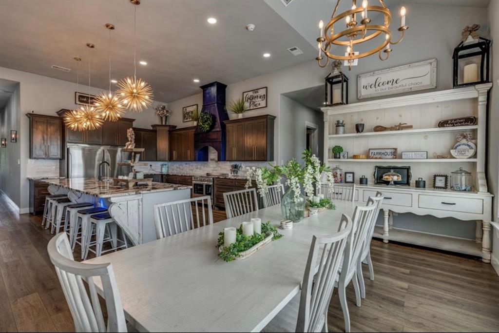 997 Ovilla Road Waxahachie, TX 75167 - Photo 28 of 32 Spacious dining area featuring wood-finish flooring, a white dining table with seating, and an overhead chandelier