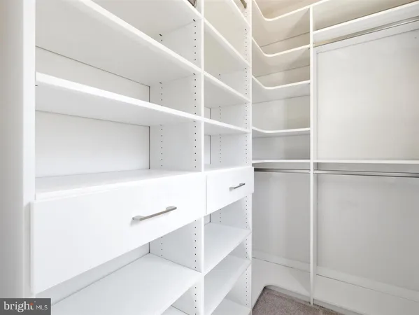 a view of walk in closet with empty racks