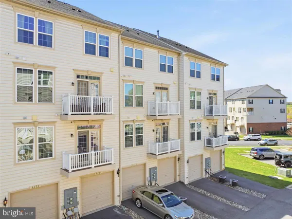 a front view of a residential apartment building with a yard in front of it