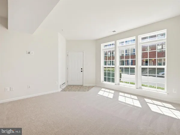 a kitchen with granite countertop a refrigerator a stove a sink and white cabinets with wooden floor