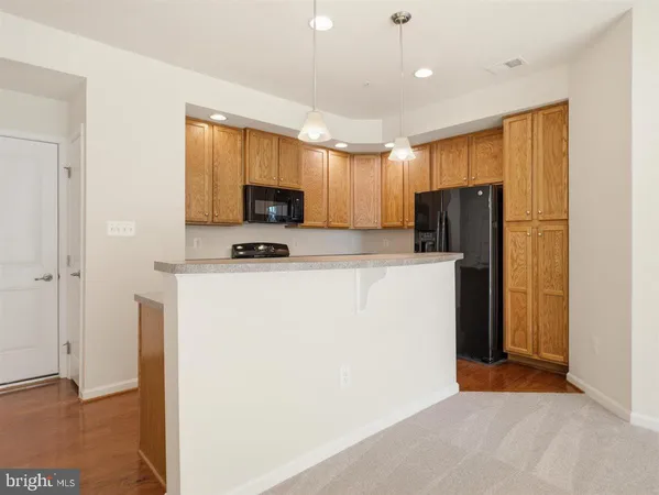 a kitchen with a sink a counter space appliances and cabinets