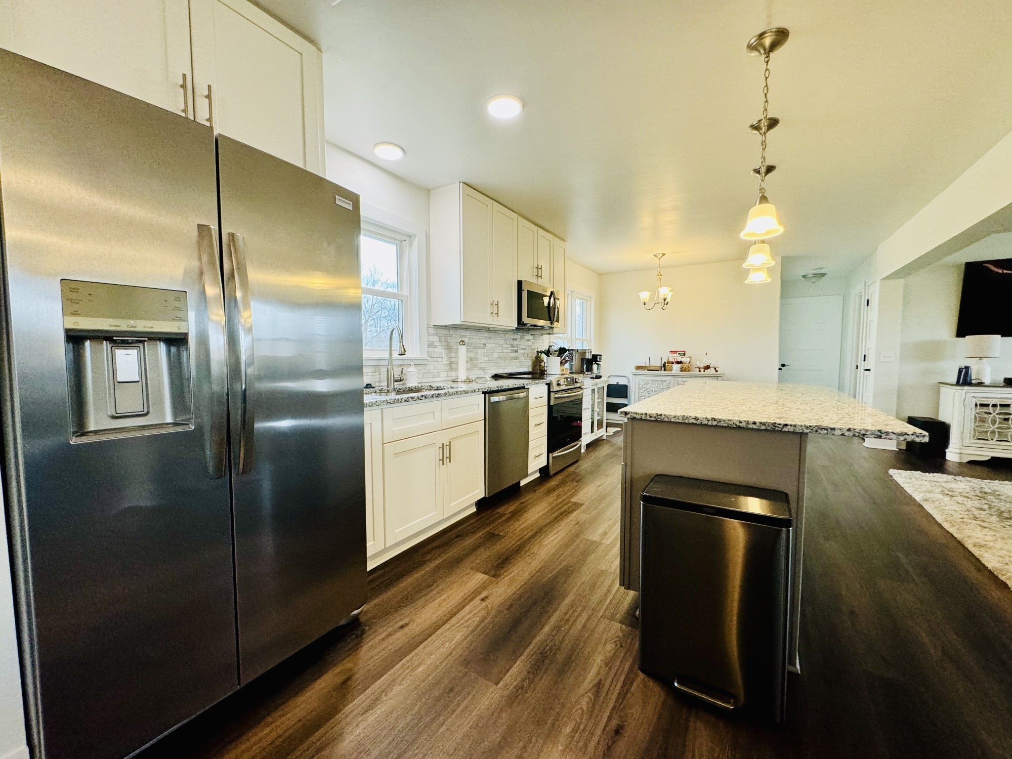 1175 Rock Church Road Dickson, TN 37055 - Photo 21 of 60 a kitchen with stainless steel appliances granite countertop a refrigerator a sink dishwasher a stove and white cabinets with wooden floor
