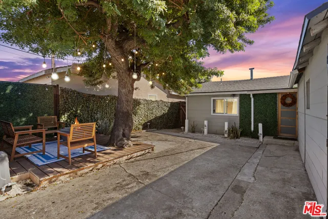 a view of backyard with outdoor seating and trees